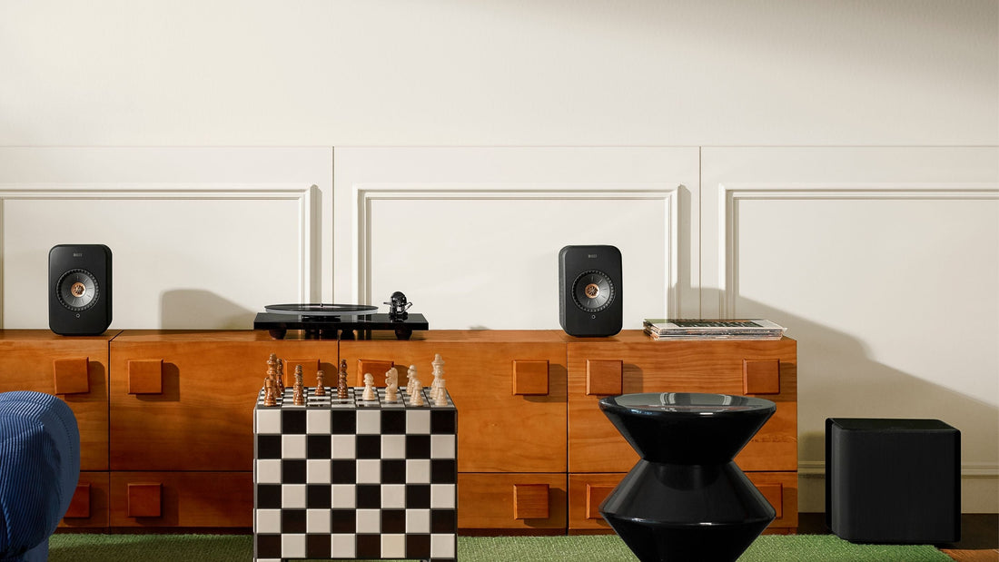 KEF Kube 8 MIE subwoofer in a modern living room next next to KEF LSX II speaker which is placed on a sideboard