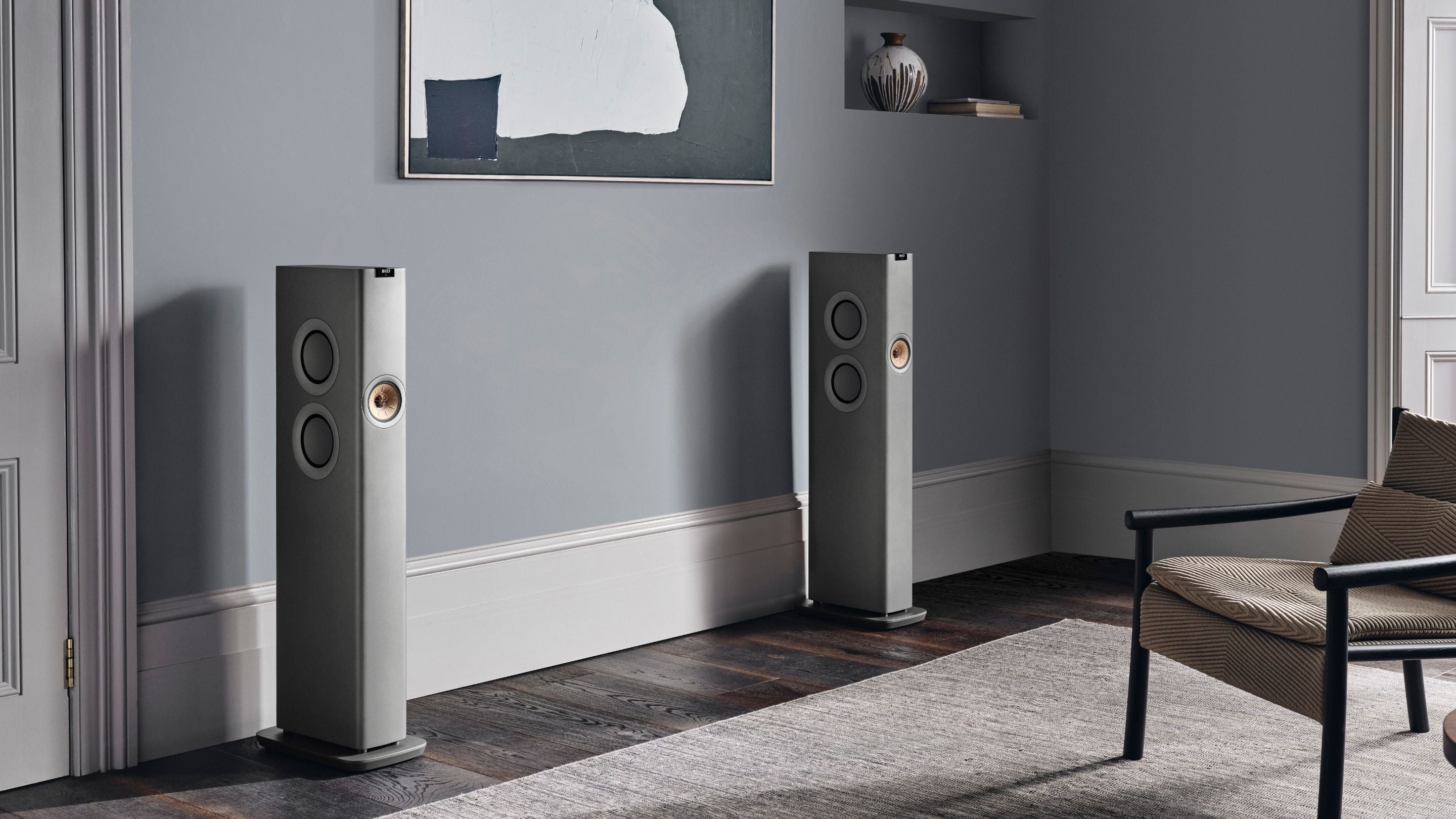 Modern interior with a wooden sideboard, decorative items, and KEF LS60 speakers.