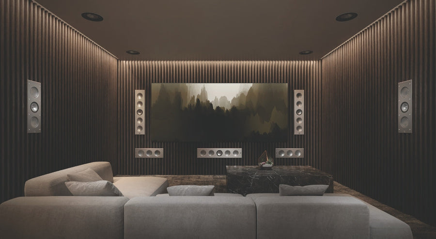 Luxury home cinema setup with wall-mounted surround speakers and large screen in a modern living room