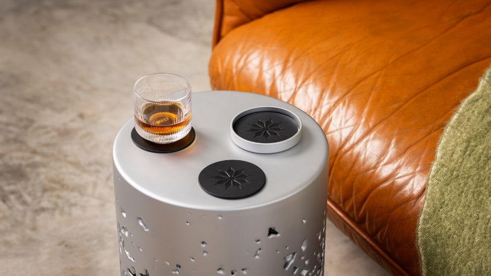 KEF coasters on couch table with whiskey.
