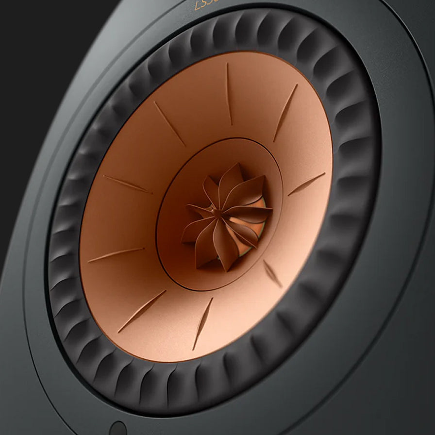 Close-up of a speaker cone with a black and copper design on a dark background